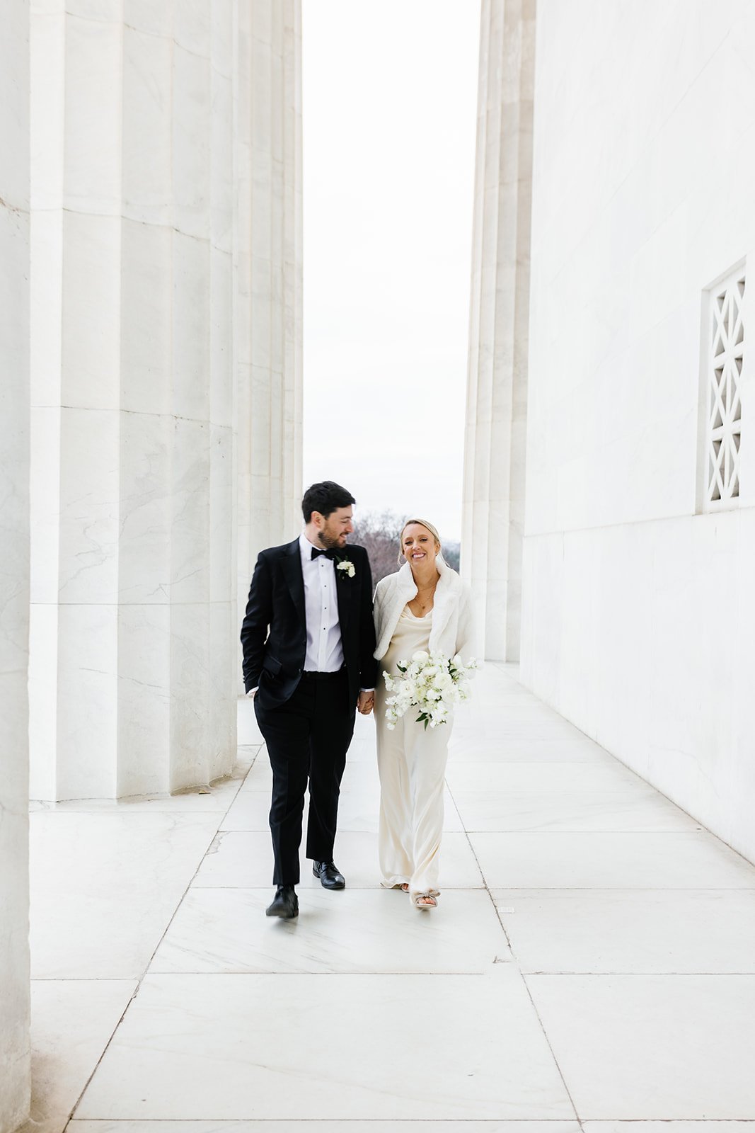 Bride and groom take photos at the Washington Monuments at the National Mall