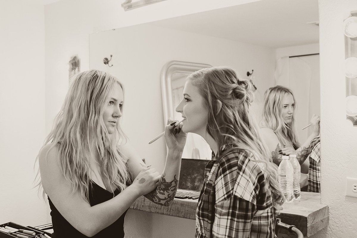 A bride getting her hair and makeup done by a makeup artist.