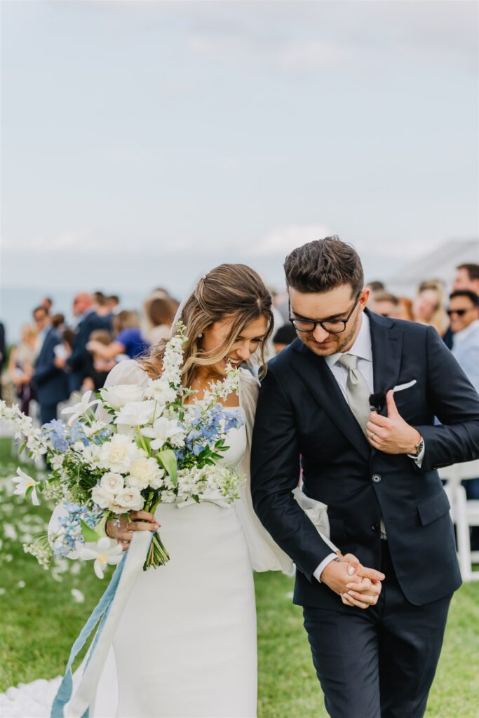 Couple leaving their wedding ceremony holding hands.