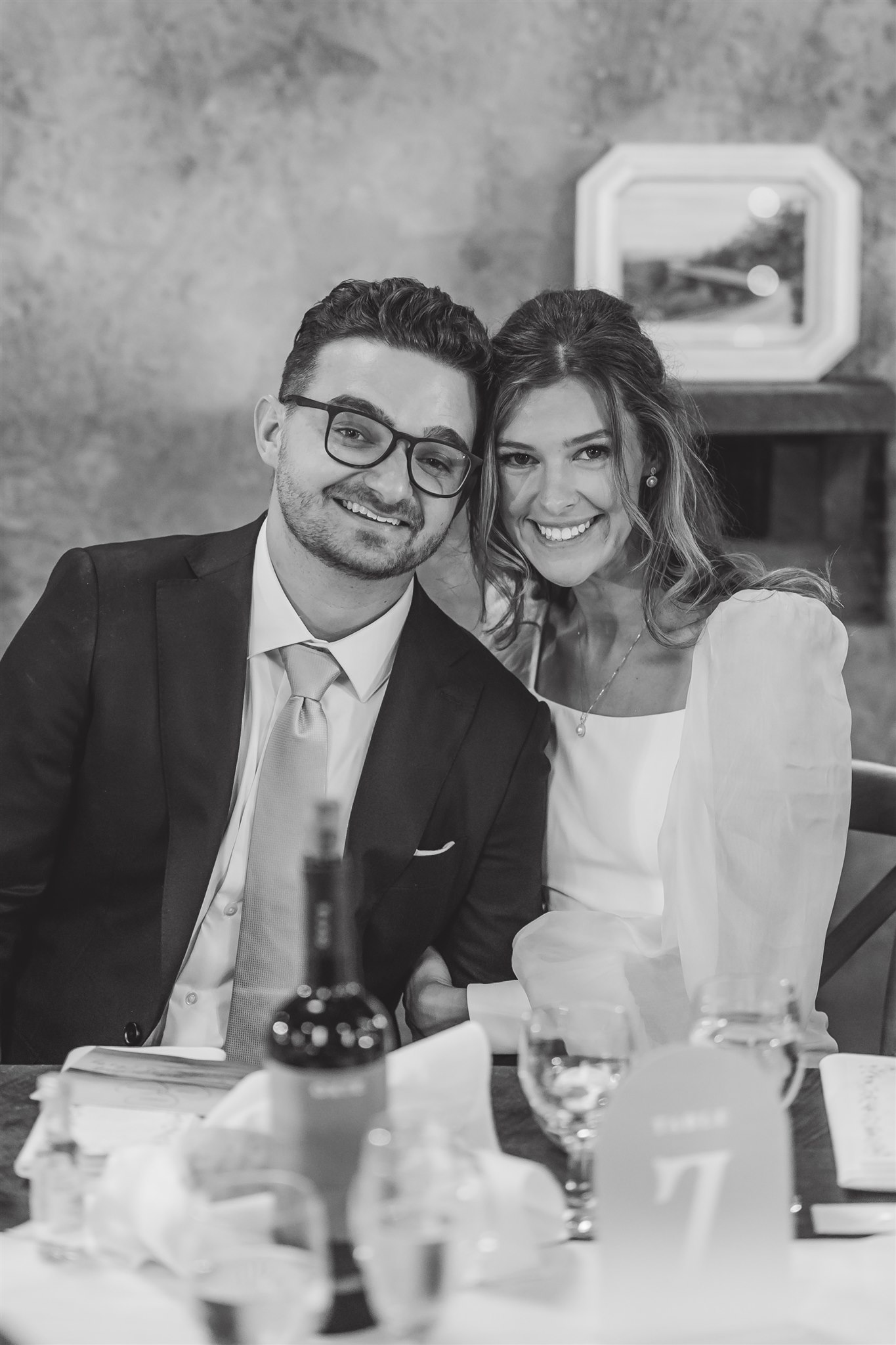 Couple sitting at their dinner table at their wedding reception. 