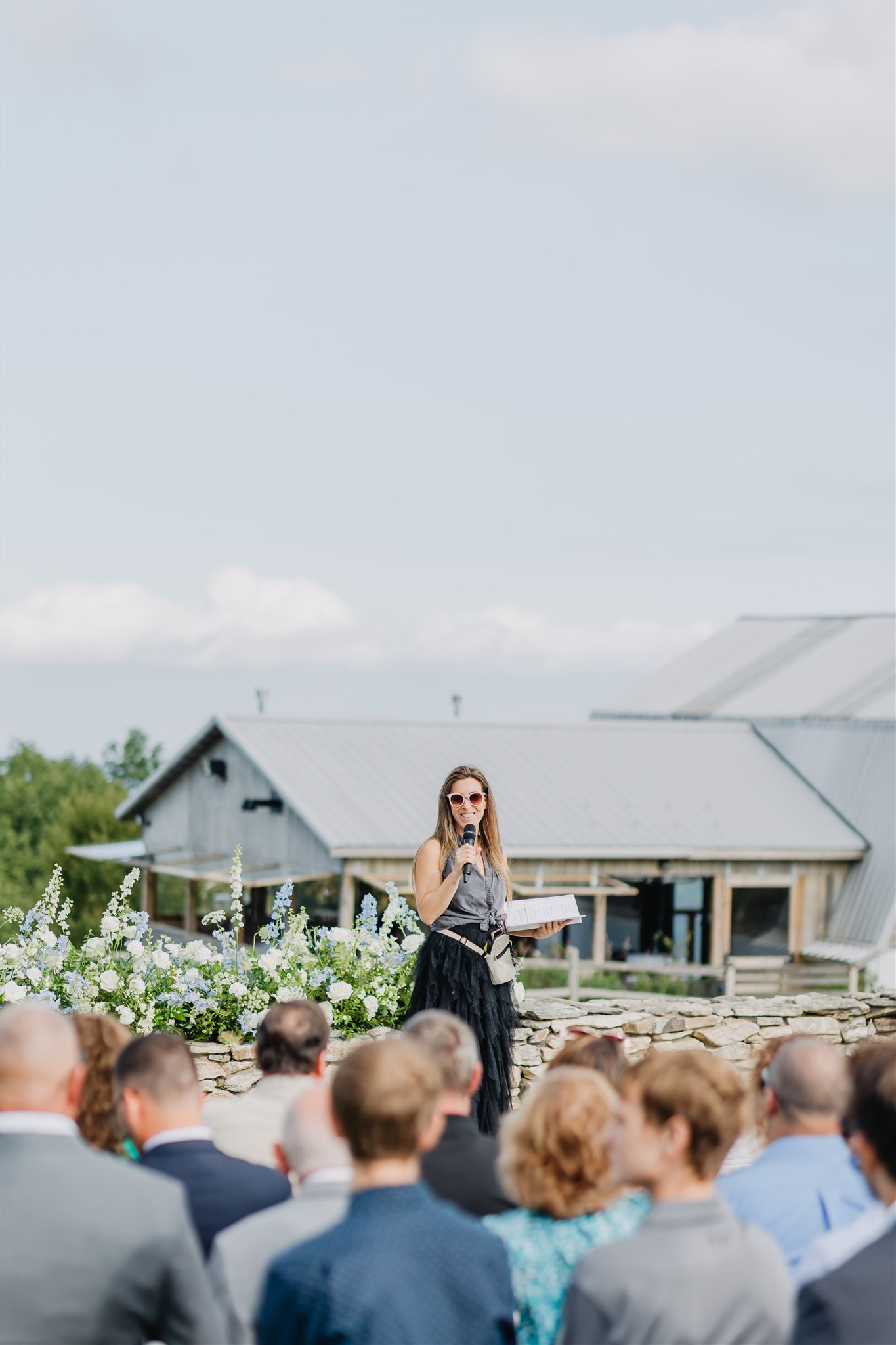 Wedding planner Meris standing at the front of the wedding ceremony prior to the ceremony giving instructions.